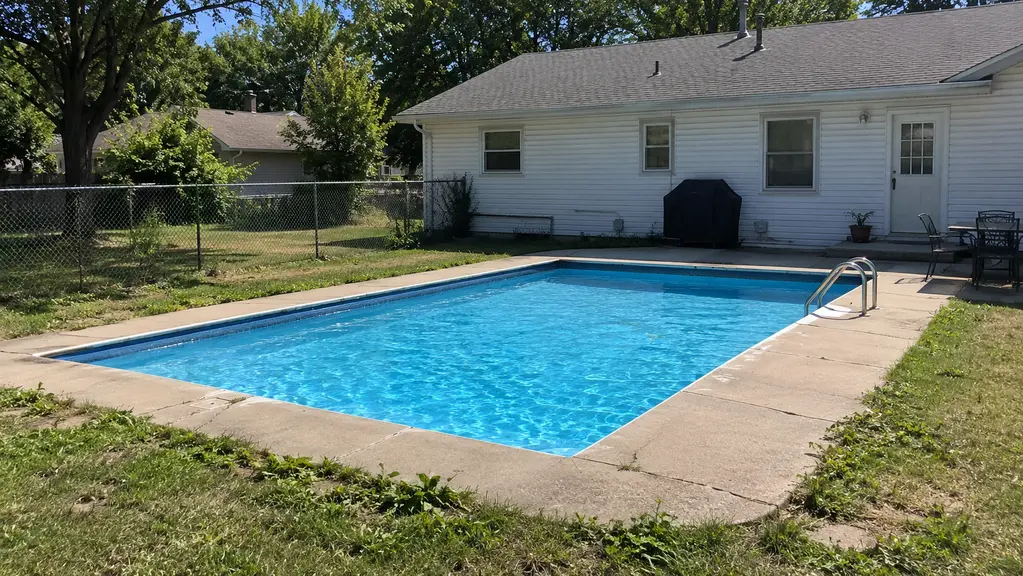 A clean backyard pool at a single-story home