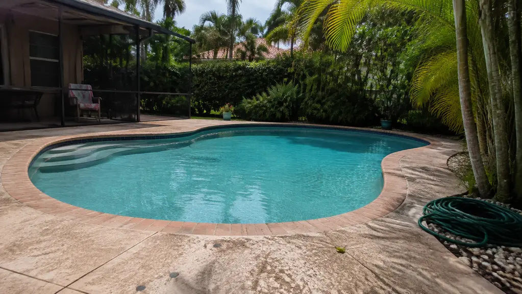 A clean kidney-shaped pool with steps